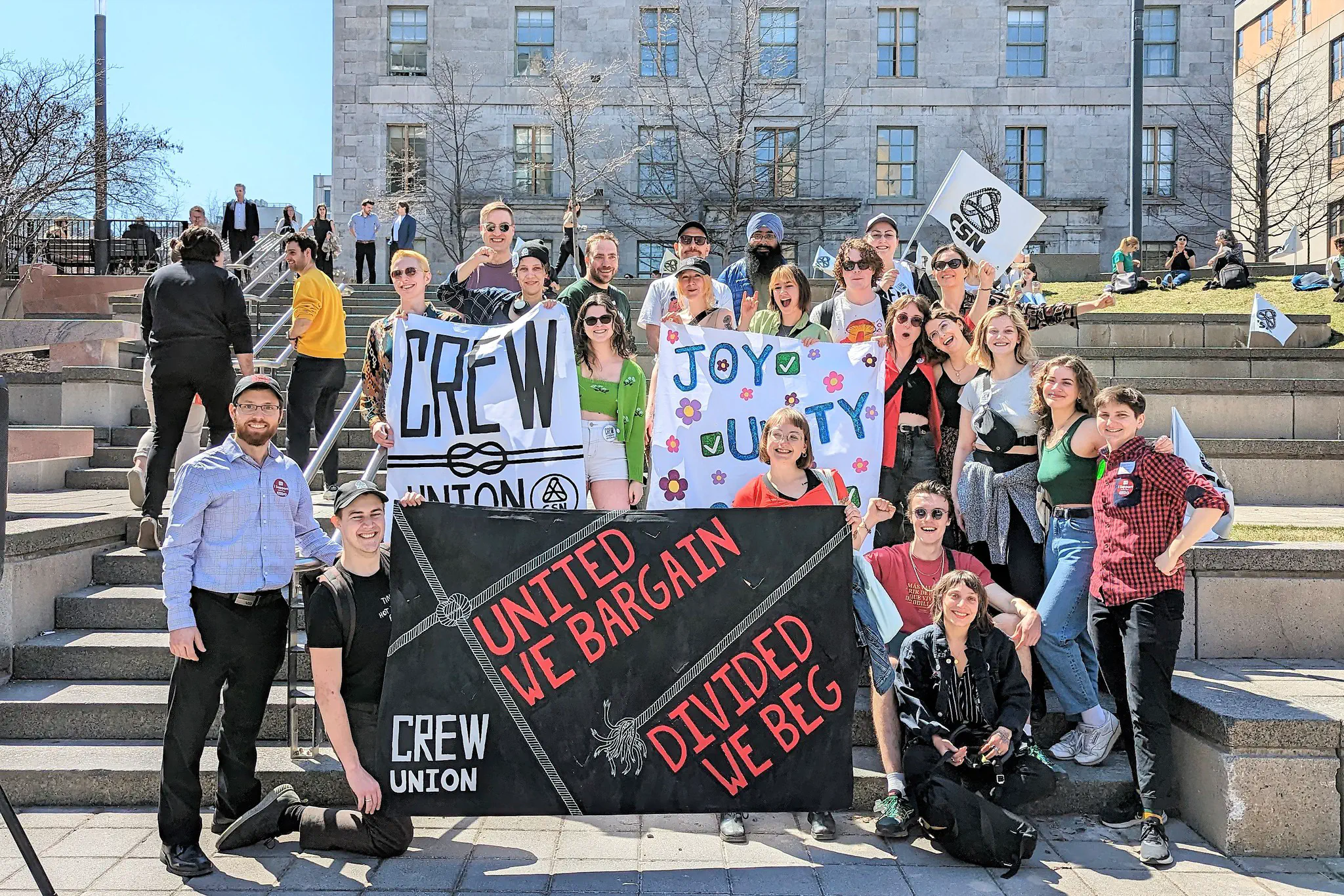 Photo of AGSEM President Mario Roy (far left) and Mobilization Officer Kiersten van Vliet (far right) pose with militants from the Concordia Research and Education Workers&rsquo; Union (CREW-CSN) at the “We Can Win a Huge Raise: AGSEM Rally for TAs” rally (April 13, 2023).