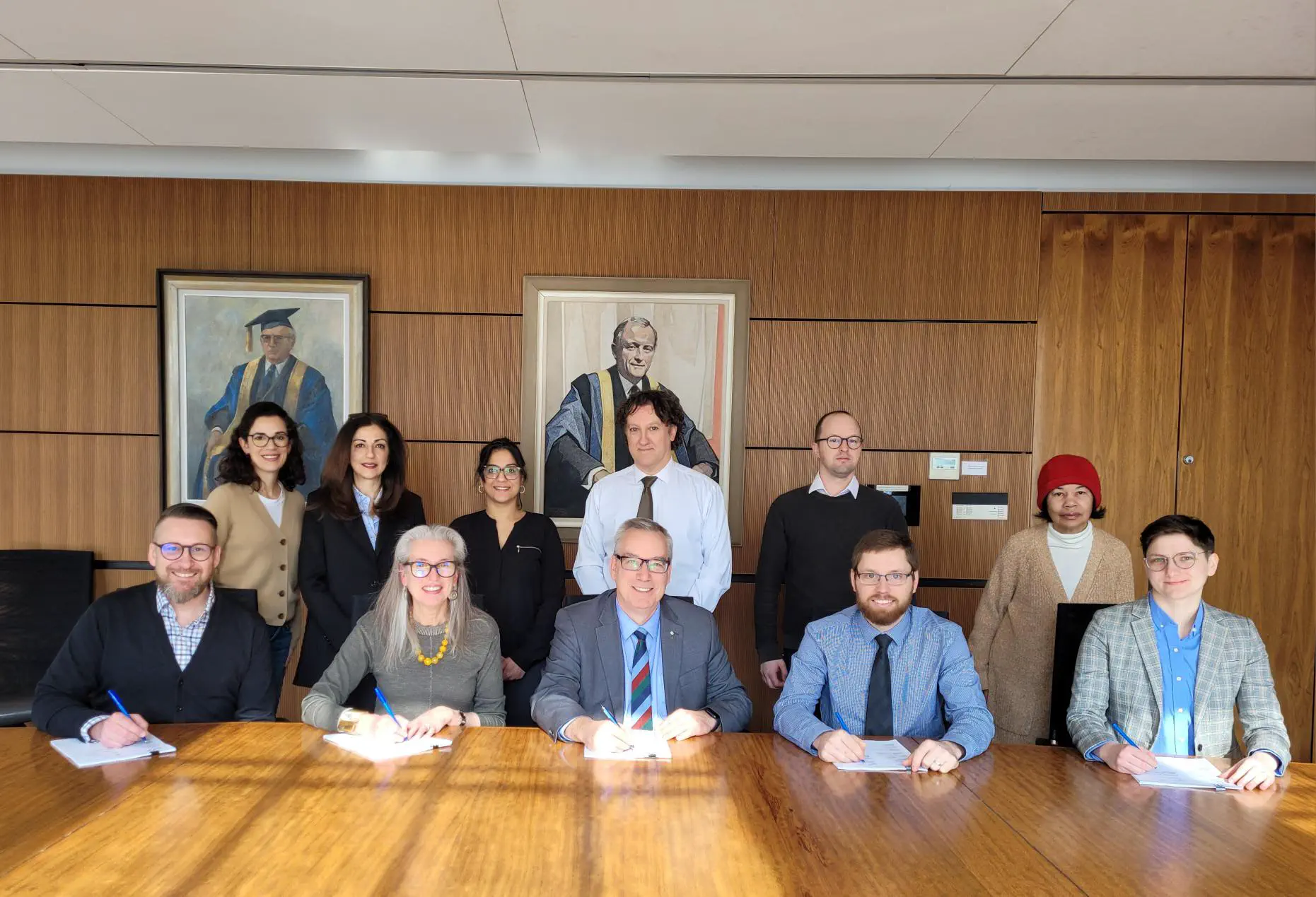 Photo du président de l’AÉÉDEM, Mario Roy, membres du comité de négociation Kiersten van Vliet et Andrea Hazelwood (Gokcan Sahin non inclus), et conseiller syndical de la FNEEQ Sébastien Boisvert, signant la nouvelle convention collective des surveillant.e.s d’examen avec des représentants de McGill (31 mars, 2023).